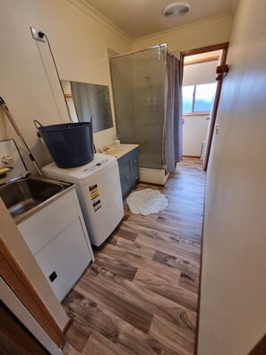 Tina con regadera, secadora de cabello, toallas, papel de baño 