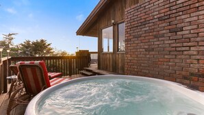 A hot tub on a wooden deck with wicker chairs and a wooden fence. - Easter Weekend Special, 20% off! Insider tip Easter egg hunt at the beach! (Manchester)