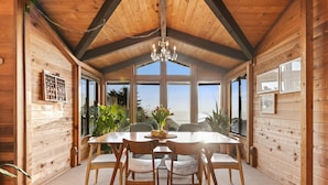 A wooden interior with a dining table, chairs, and a chandelier. - Easter Weekend Special, 20% off! Insider tip Easter egg hunt at the beach! (Manchester)