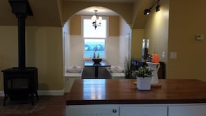 Une cuisine dotée d’un plan de travail en bois, d’une cuisinière et d’une fenêtre donnant sur un paysage magnifique.