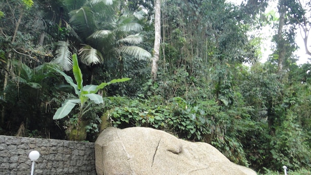 Una gran formación rocosa con un muro de piedra y un camino empedrado.