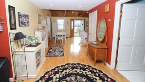 A hallway with a dining area, a mirror, and a door. - 18 Knott Ave (Sandwich)