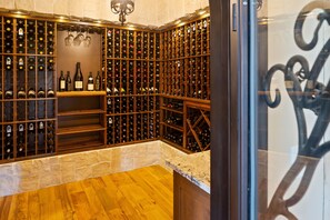Wine enthusiasts can explore an extensive wine collection in this cellar, featuring a diverse selection of bottles on wooden racks.
