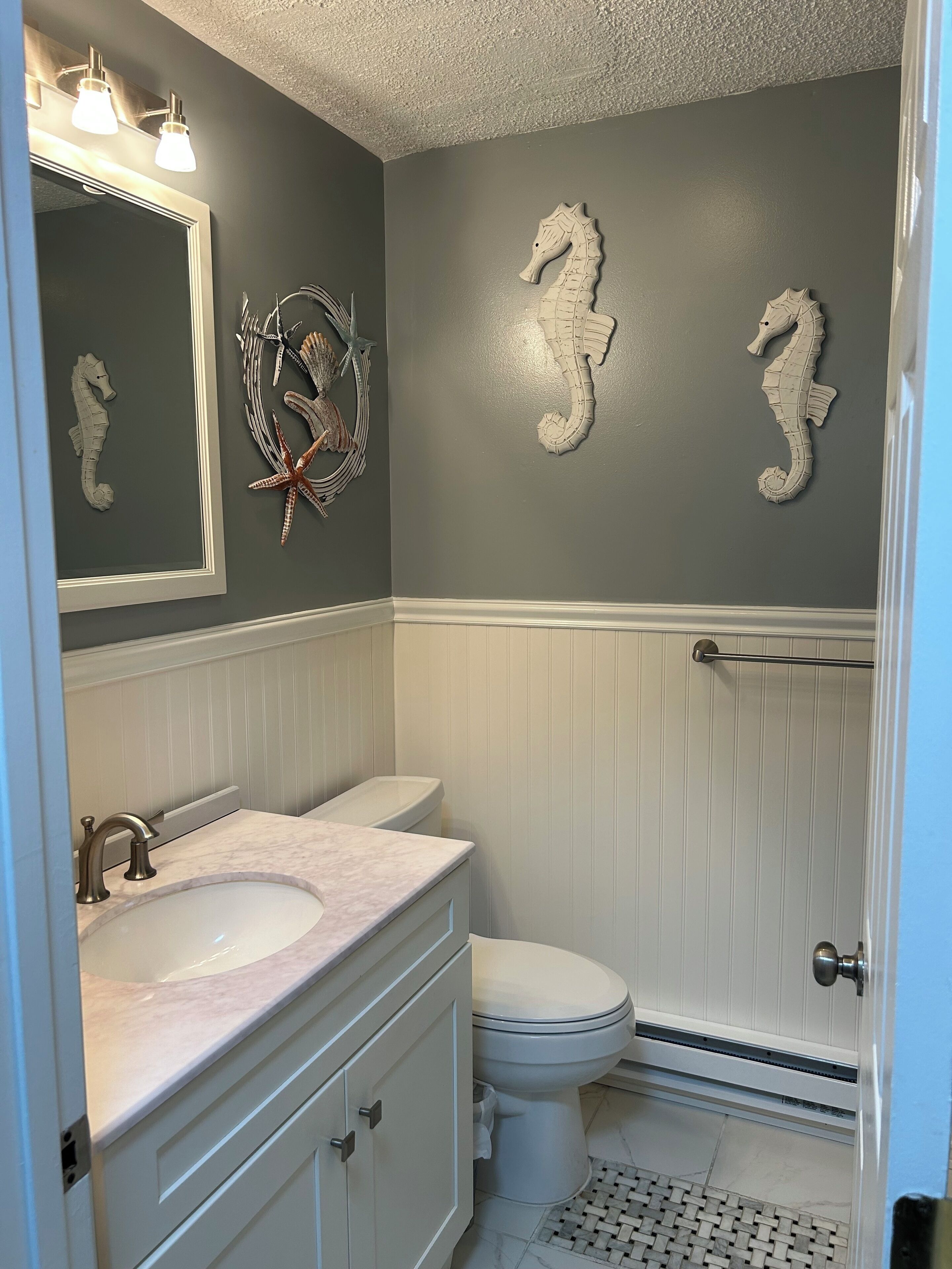 A bathroom with a vanity, a toilet, and a shower area.