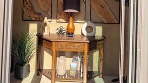 A room with a wooden console table, a hanging lamp, framed wood art, a potted plant, and a tiled floor. - LAZY RIVER!  SLIDE and WATERFALLS!  GAMEROOM. (Palm Springs)