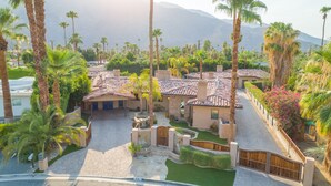 A residential area with multiple houses, palm trees, and a mountain in the background. - LAZY RIVER!  SLIDE and WATERFALLS!  GAMEROOM. (Palm Springs)