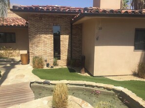 Stunning home with a well-manicured lawn and a small water feature.