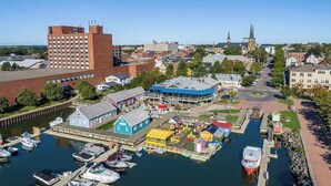 A marina with boats docked, a blue building, and a church in the background. - Luxury Waterfront Marina Condo in Downtown (Charlottetown)