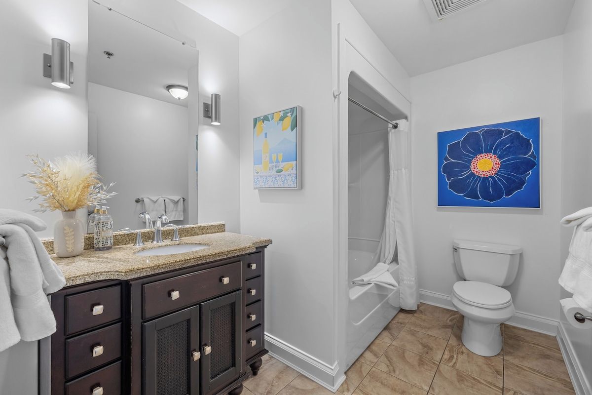 A modern bathroom with a vanity, sink, and toilet.