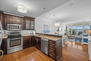 Una cocina moderna con electrodomésticos de acero inoxidable, armarios de madera y una isla grande.