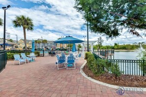 A waterfront patio with outdoor seating, a pool, and a view of the lake.