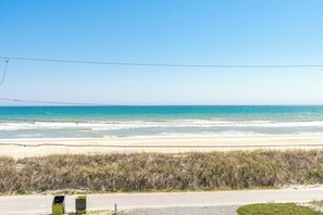 A beach view with a road, a green dumpster, and a clear sky. - Happy Days - Endless Ocean Views; 3BR; Easy Beach Access (North Topsail Beach)