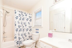 A bathroom with a shower, toilet, and a sink with a mirror. - Happy Days - Endless Ocean Views; 3BR; Easy Beach Access (North Topsail Beach)