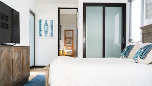 A bedroom with a large bed, a TV, a wardrobe, and a door leading to a bathroom. - Welcome to the Lucky Penny! (Ocean Park)