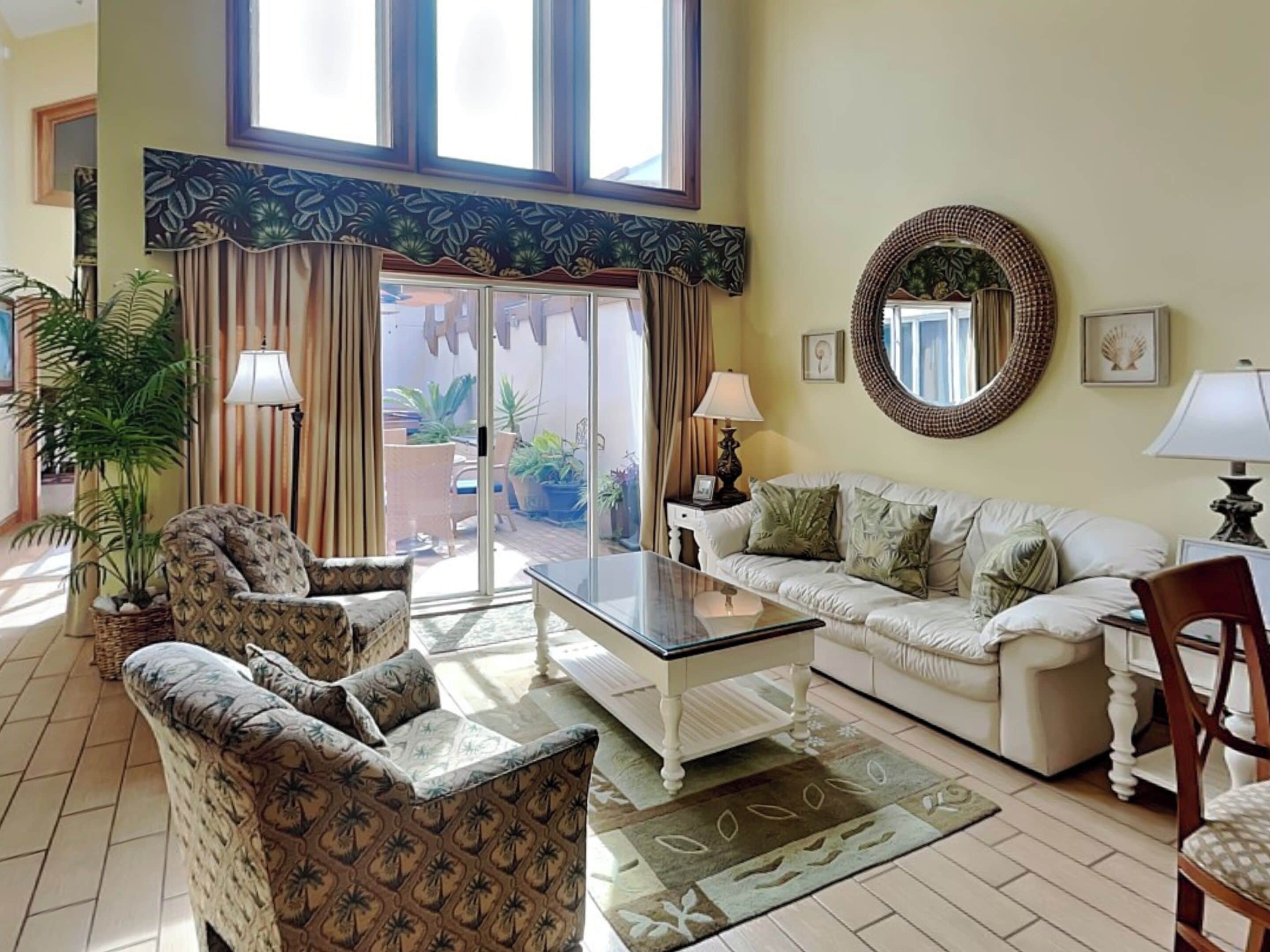 A living room with a sofa, armchairs, a coffee table, and a large window.