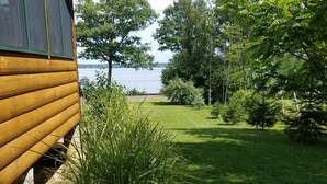 Une cabane en bois offrant une vue sur un lac et la végétation environnante.