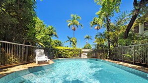 A clear blue swimming pool surrounded by a metal fence, with a white lounge chair and lush greenery in the background. - The VILLA with THE VIEW - Villa 4 Island Point Road. (Port Douglas)