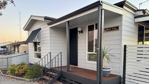 A modern single-story house with a covered porch, a small staircase, and a potted plant. - Family Getaway in Moonta Bay (Moonta Bay)