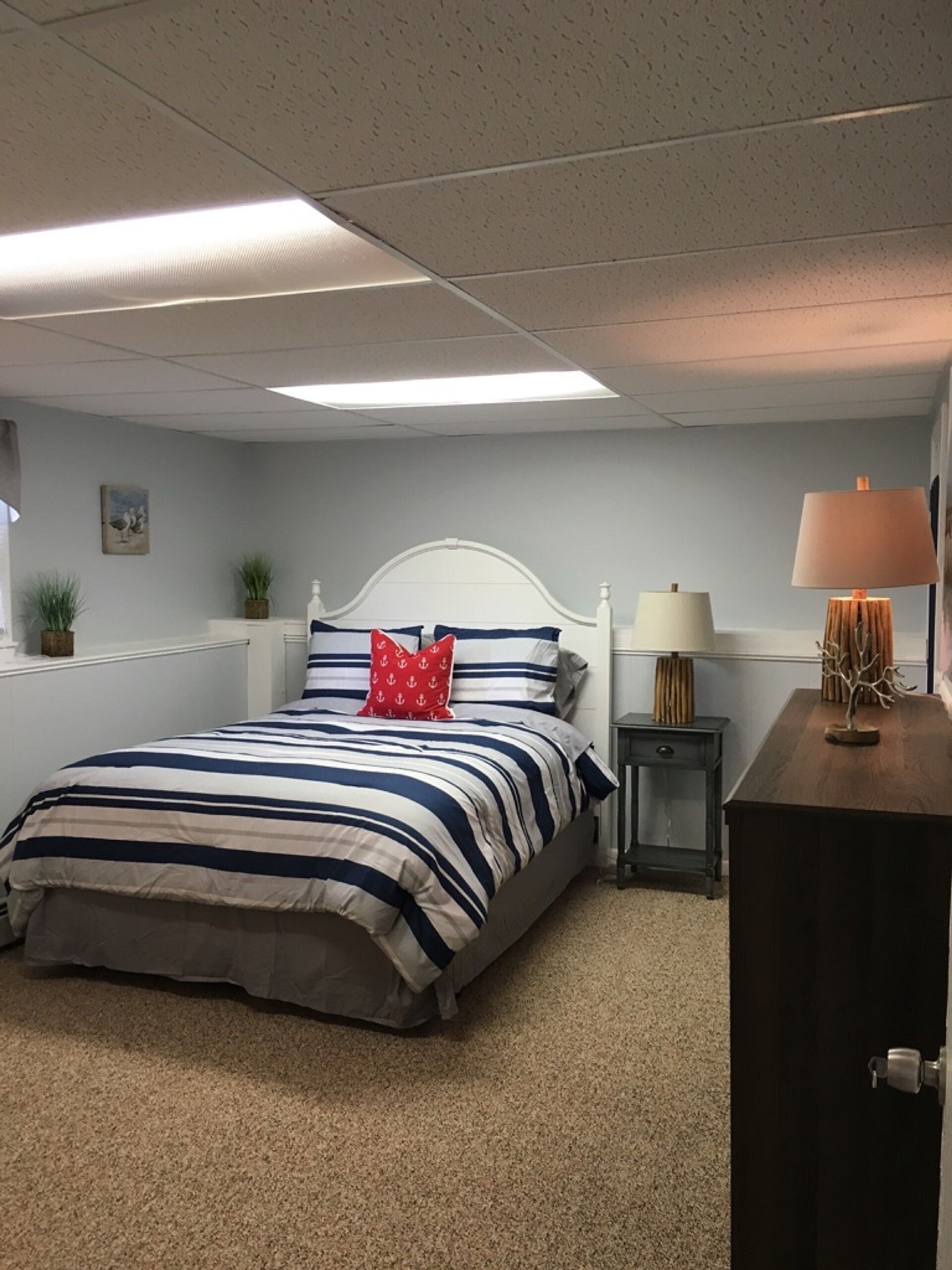 Ein Schlafzimmer mit Bett, Nachttischen, einer Lampe und einem Schminktisch.