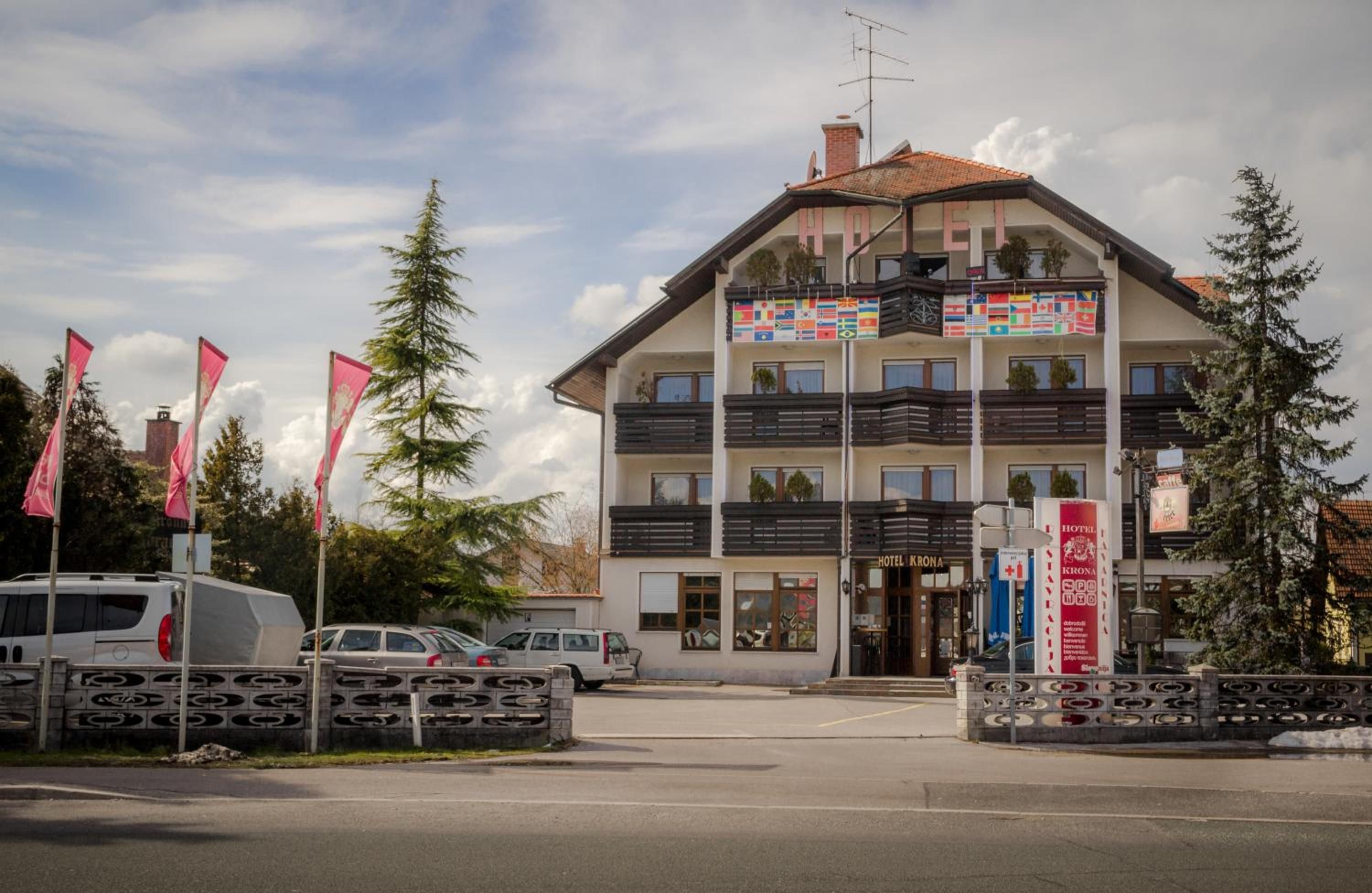 Ein mehrstöckiges Hotel mit Balkonen, einem Parkplatz und Flaggen.