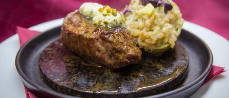 A plate with a steak and a side of rice.