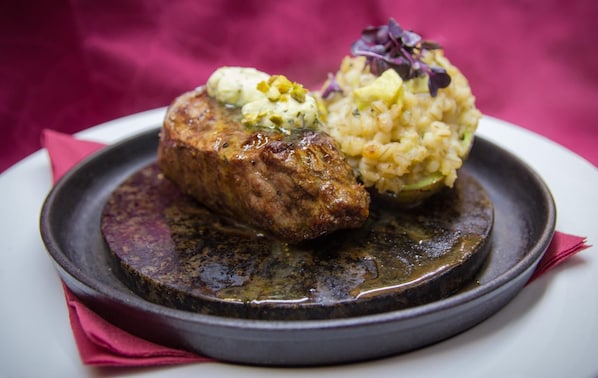 Un plato con un bistec y una guarnición de arroz.