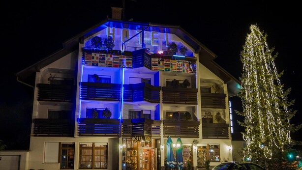 Un hôtel à plusieurs étages, doté de balcons et décoré d’un sapin de Noël.