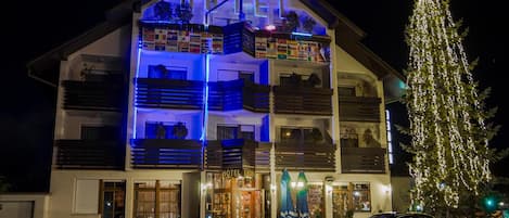 A hotel with a multi-story structure, balconies, and a Christmas tree.