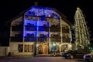 Un hotel con estructura de varios pisos, balcones y un árbol de Navidad.