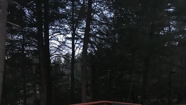 An outdoor deck with wicker furniture, a fire pit, and a railing. - Lakefront Catskills Lodge (Monticello)
