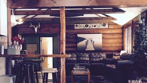 A rustic wooden interior with a bar area, seating, and a fireplace. - Lakefront Catskills Lodge (Monticello)