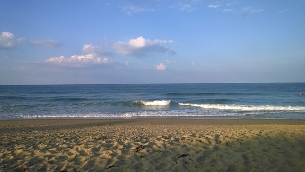 A beach with sand and waves.