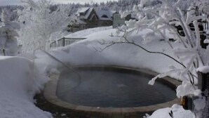 A snow-covered landscape with a circular pond, buildings, and trees. - 🎿 Ski-In\Out Penthouse. Sunrise 🌅 Mtn ⛰️ Views. Snowshoe’s Most Luxurious Lodge 🌅 (Snowshoe)