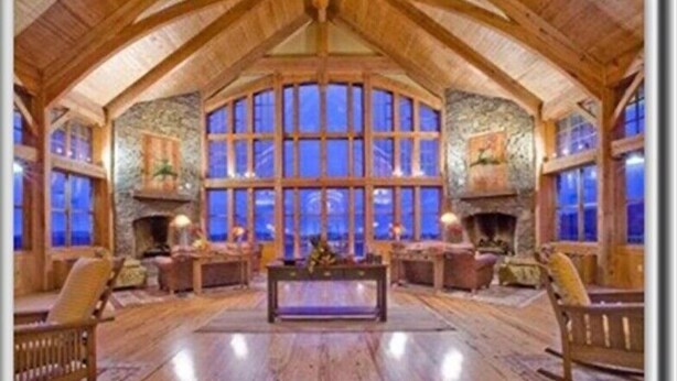 A log cabin interior with a stone fireplace, wooden furniture, and large windows. - 🎿 Ski-In\Out Penthouse. Sunrise 🌅 Mtn ⛰️ Views. Snowshoe’s Most Luxurious Lodge 🌅 (Snowshoe)