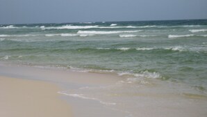 Una playa con olas que se acercan a la orilla.