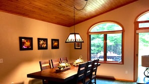 Un coin repas avec une table en bois, des chaises et un luminaire suspendu.