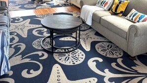 A spacious living room with a ceiling fan, a dining area with a table and chairs, a sofa with colorful cushions, and a patterned rug. - Cape May Vacation Rentals- Great Location! Just BLOCK & 1/2 to BEACH and TOWN!  (Cape May)