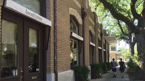 A row of buildings with 'localiten' signs, a sidewalk, and pedestrians.