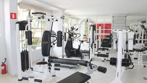 Un gimnasio con varios equipos de ejercicio, incluyendo cintas de correr, máquinas de pesas y pesas libres.