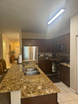A kitchen with granite countertops, stainless steel appliances, and wooden cabinets.