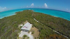 An aerial view of a property with a large house surrounded by dense vegetation and turquoise waters. - Las Breezes 5 Bedroom Villa, With 1/2 Mile Private Beach On Hooper's Bay (George Town)