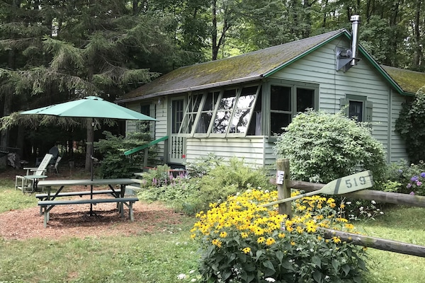 Summer cabin with daisies.
Parking by split rail fence.