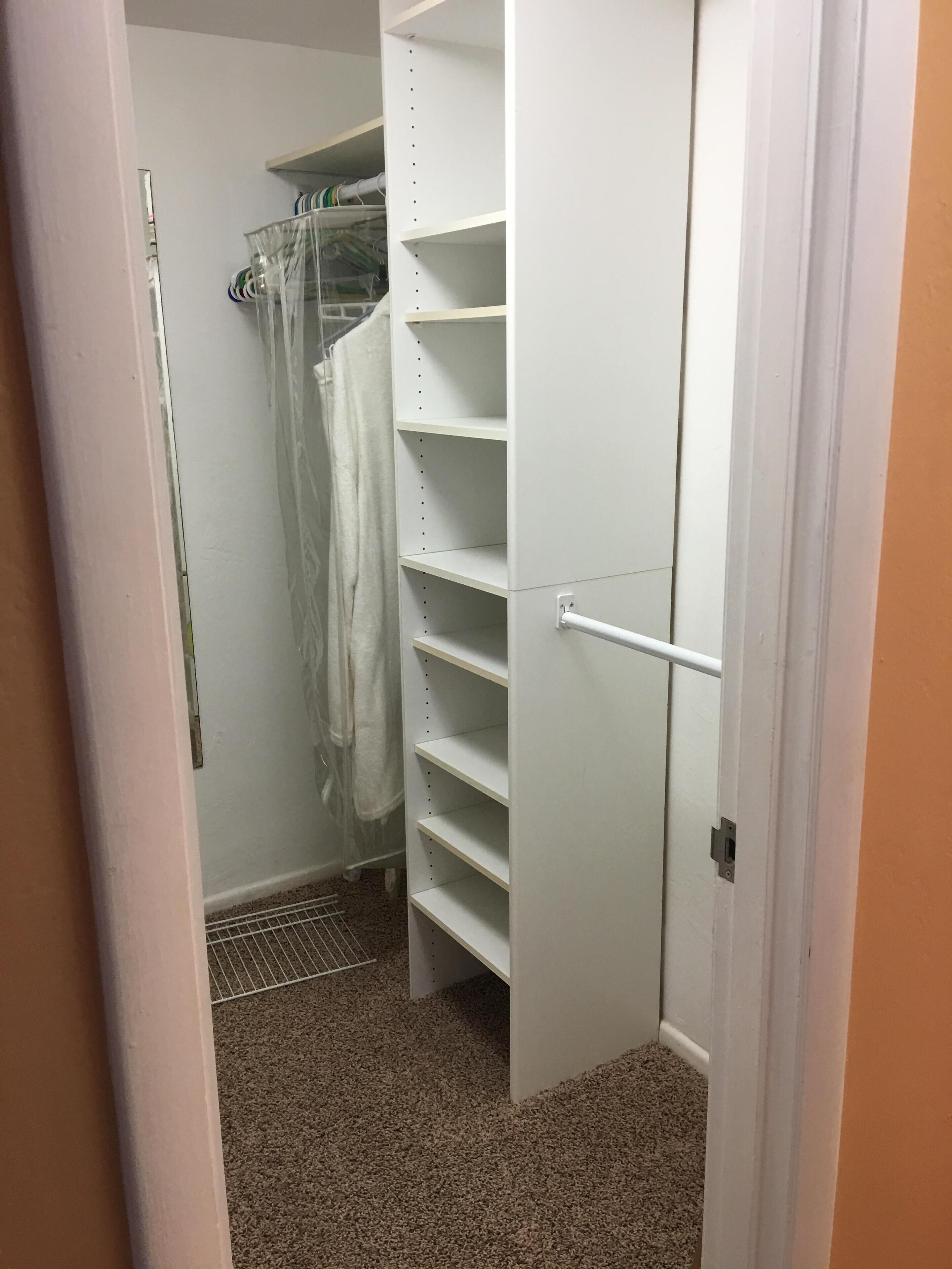 Un dressing avec des étagères ouvertes et une tringle pour suspendre les vêtements.
