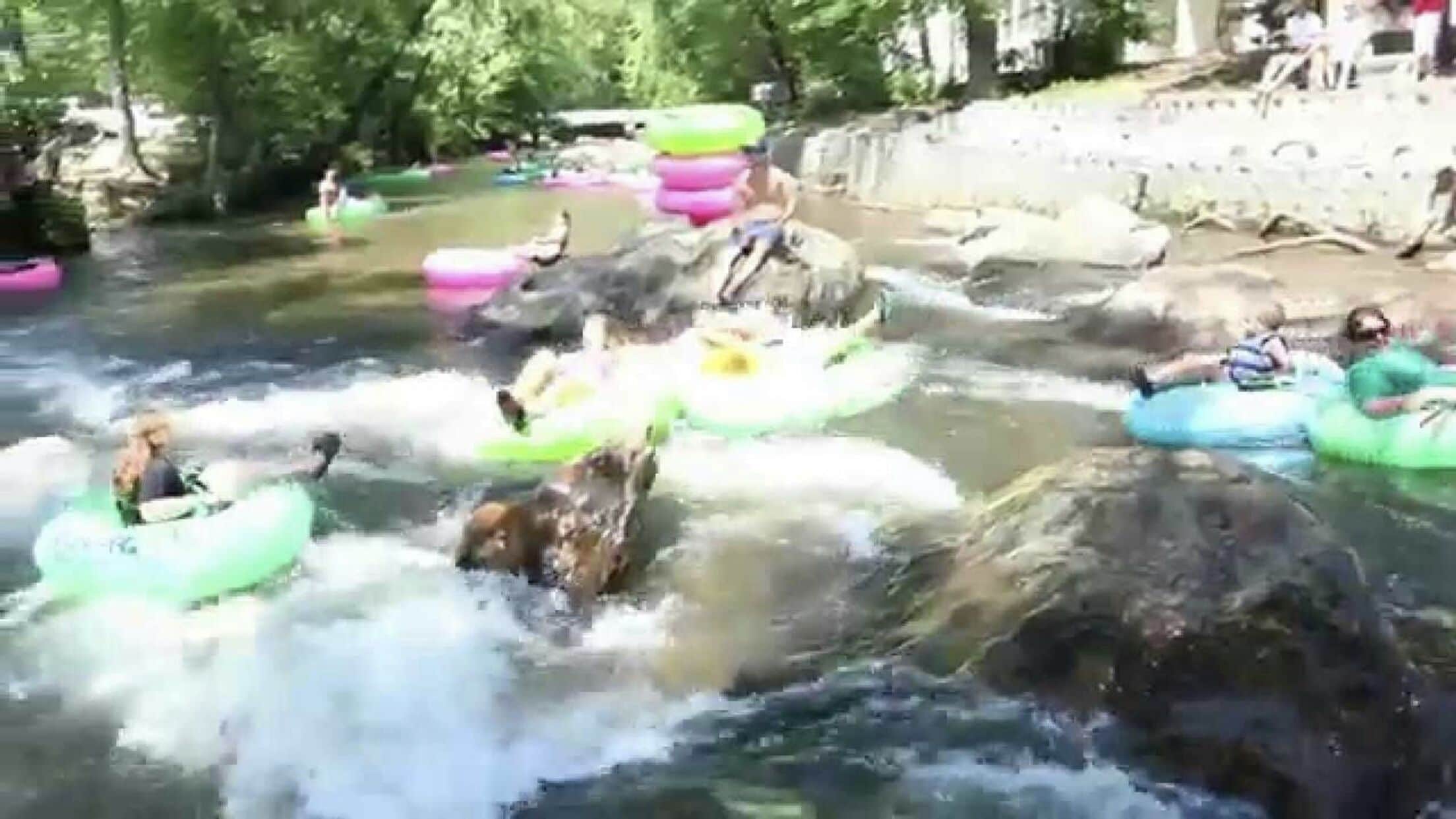 A river with people on inflatable rafts.