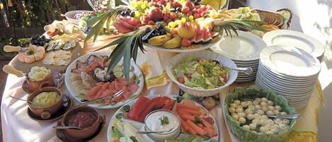 A buffet table with various food items and dishes.