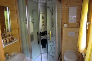 Un baño con ducha acristalada, inodoro y lavamanos.