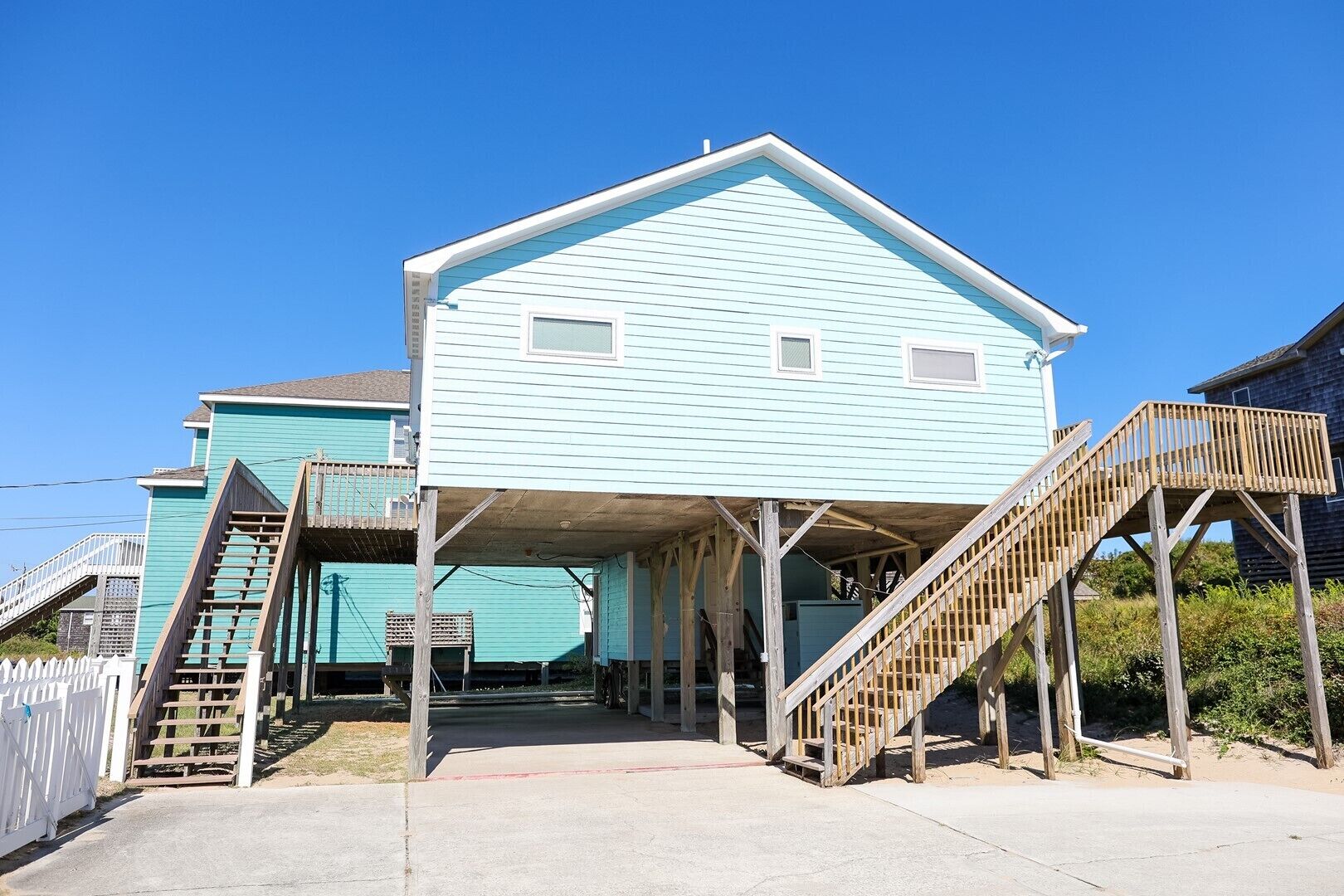 A two-story house with a covered porch and wooden stairs leading to the entrance.