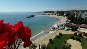 Blick auf die Küste mit Strand, Promenade und Gebäuden.