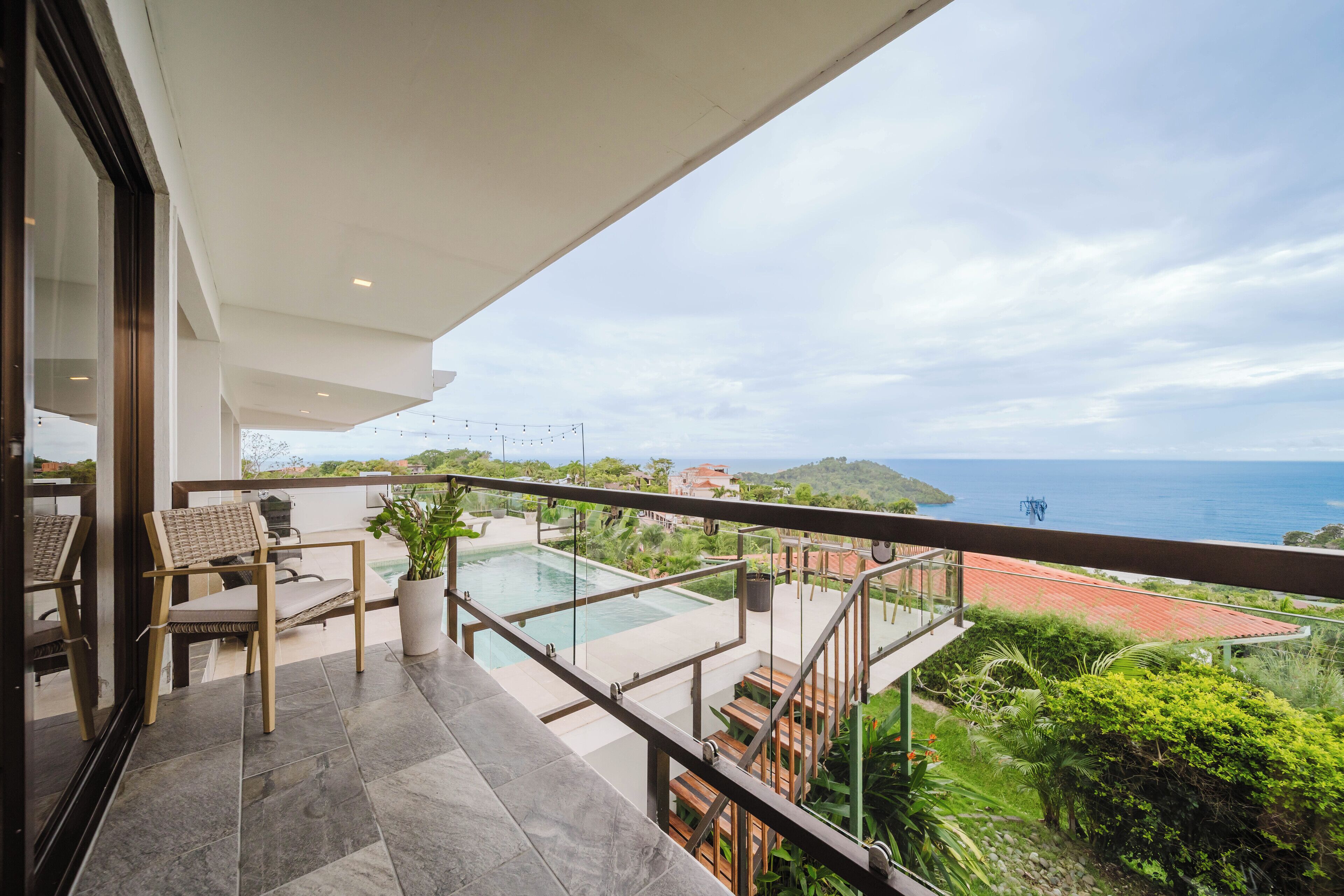 Un balcon avec une piscine, du mobilier d’extérieur et une vue sur la mer.
