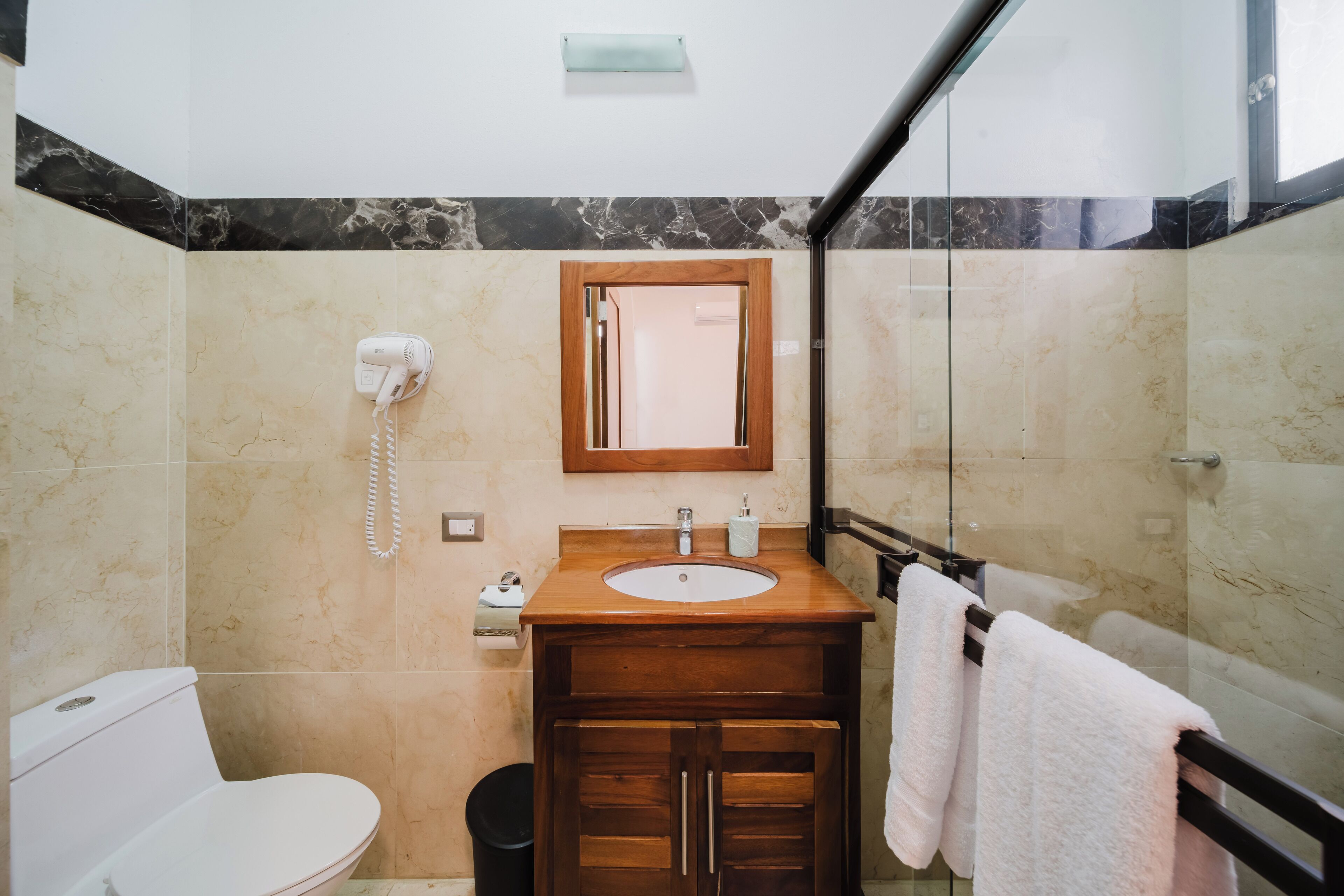 A bathroom with a toilet, sink, and shower area.